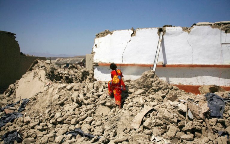 An earthquake survivor searches for their belongings in the rubble of a mud house after it collapsed following the quake in the town of Awaran, southwestern Pakistani province of Baluchistan, September 26, 2013. The death toll from a powerful earthquake in southwest Pakistan rose to 327 on Wednesday after hundreds of mud houses collapsed on residents throughout the remote and thinly populated area, local officials said,  REUTERS/Naseer Ahmed   (PAKISTAN - Tags: ENVIRONMENT DISASTER)